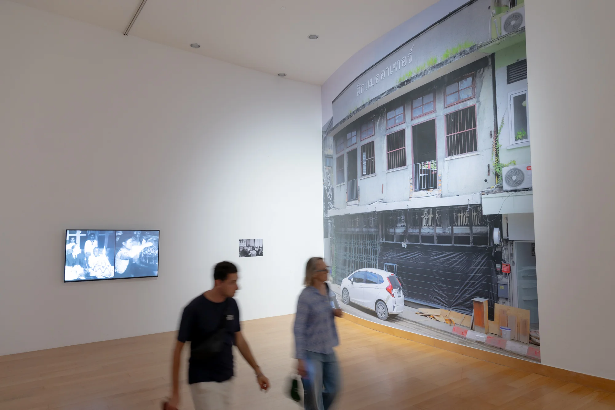 Som Supaparinya, The Half of Us, , 2025. Video, B&W, silence, 6 mins. Footages and stills courtesy of Film Archive Division, Lao Department of Cinema, the Buddhist Archives of Luang Prabang, Mr. Phetrasa Phetrasy, and the Thai Film Archive (Public Organisation),  SEATO meeting (Bangkok), 1961. , A meeting of the Southeast Asia Treaty Organisation Photo by John Dominis Courtesy of LIFE and MacArther Building (Chiang Mai), 2024. , Photo: BACC. Courtesy of BACC © BACC