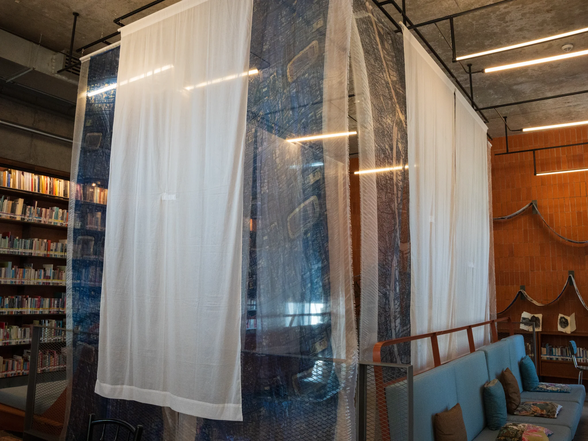 Keeta Isran, Ban Krua Ban Khaek, 2025. Embroidery, printing and soot painting on fabric, antique wooden spinning wheel, and video, Dimension variable. Photo: Apichote Poonperm. Courtesy of the Jim Thompson Art Center and the James H.W. Thompson Foundation © Jim Thompson Art Center