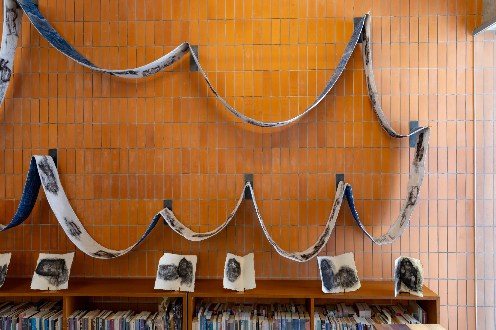 Keeta Isran, Ban Krua Ban Khaek, 2025. Embroidery, printing and soot painting on fabric, antique wooden spinning wheel, and video, Dimension variable. Photo: BACC. Courtesy of BACC © BACC